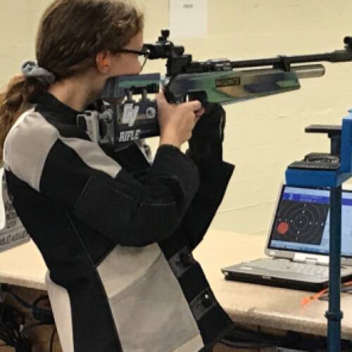 Rifle athlete tracks shot with target software on a computer to report scoring.